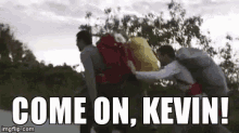 a man is carrying a backpack on his back and says `` come on , kevin '' .