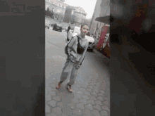 a woman is walking down a sidewalk with a backpack .