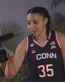 a woman wearing a jersey that says uconn 35 on it