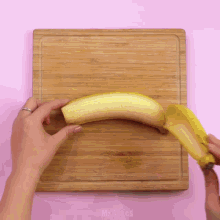 a person is peeling a banana on a wooden cutting board that says mr.cakes