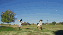 a woman in a blue dress is dancing in a field