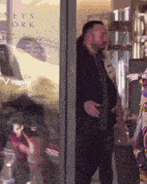 a woman is standing in front of a glass door that says neys york