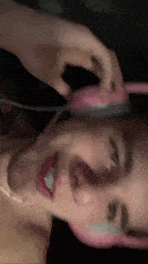 a close up of a person wearing pink bunny ears headphones
