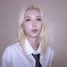 a woman with blonde hair is wearing a white striped shirt and tie