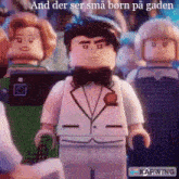 a lego man in a tuxedo and bow tie is standing in front of a group of people .