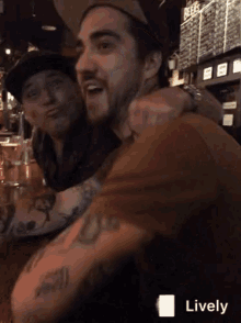 a man with a tattoo on his arm is sitting next to another man with a tattoo on his arm