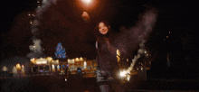 a blurred image of a christmas tree with fireworks going off in the background