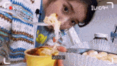 a woman is eating a spoonful of food and the words iu cam are on the bottom of the screen