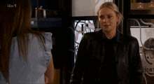a woman in a leather jacket is talking to another woman and the words * gay panic * are visible