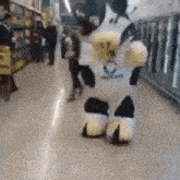 a person dressed in a cow costume is walking down a hallway