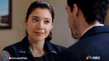 a man and a woman are looking at each other and the woman is wearing a jacket that says chicago fire on it