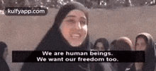 a woman in a hijab is standing in front of a group of people and saying we are human beings .