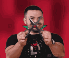 a man with a beard is holding a pair of scissors in his hands