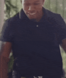 a man in a black shirt is smiling and looking to the side