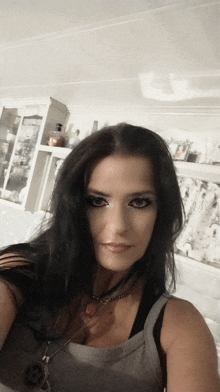 a woman taking a selfie in front of a shelf with a bottle of perfume on it