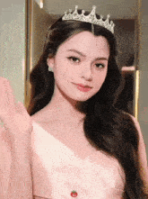 a woman wearing a pink dress and a tiara with a tomato on the bottom