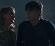 a man and a woman are standing next to each other in a dark room