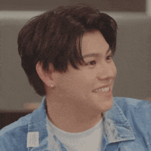 a young man wearing a blue jacket and a white shirt smiles