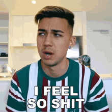a man wearing a striped shirt that says i feel so shit