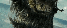 a large statue of a monster is floating in the air near the ocean .