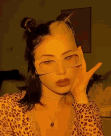 a woman wearing glasses and a necklace with a heart shaped pendant