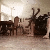 a person is doing a handstand in a living room with a spider in the background