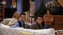 a group of people sitting on a couch in front of a tbs sign