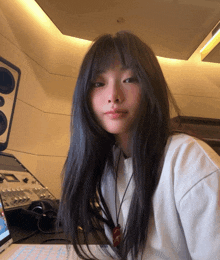 a woman with long black hair is sitting in front of a laptop computer