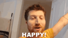 a man in a yellow shirt says " happy " with his arms outstretched