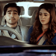a man is driving a car with a woman in the back seat looking at him