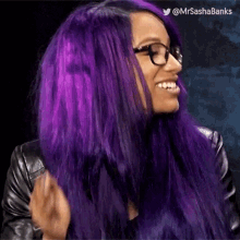 a woman with purple hair and glasses is wearing a leather jacket .