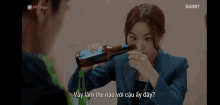 a woman drinking from a bottle with the word danet on the bottom right