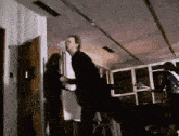 a man in a suit is standing in a room with a woman