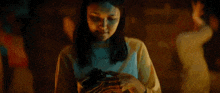 a woman is holding a camera in her hands in the dark .