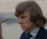 a close up of a man 's face with long brown hair