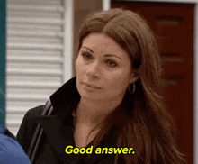 a woman in a black coat says good answer in yellow letters