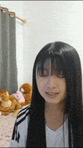 a girl with long black hair and bangs looks at the camera with her eyes closed