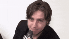 a close up of a person holding a microphone with the letters mtv on it