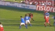 a group of soccer players are playing on a field with a sign that says capital ristor