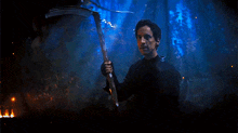 a man is holding a scythe in a dark room