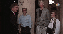 a group of people are standing in front of a nbc sign