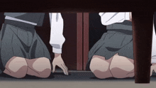 two girls are kneeling under a table and touching each other 's feet