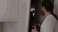 a man giving a thumbs up in front of a door