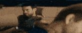 a man in a black tank top is looking at another man in a blue tank top