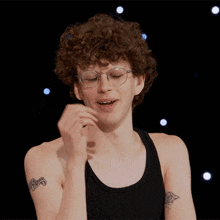 a man with curly hair and glasses has a tattoo on his arm that says ' chicago '