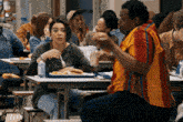 a group of people are sitting at tables eating food