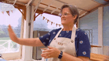 a woman wearing an apron with rita written on it