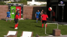 a group of people are playing soccer in front of a building that has the word big brother on it