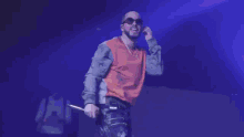 a man wearing sunglasses is standing in front of a fire on a stage