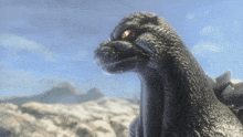 a close up of a statue of a monster with a blue sky in the background